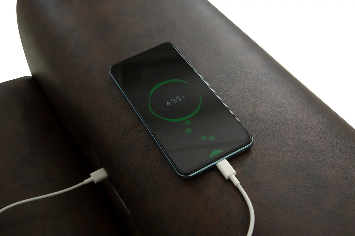 closeup of sofa arm with iphone charging from usb port