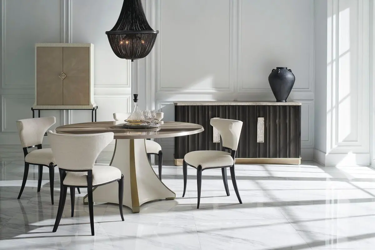 staged dining room showing partial round dining table in bright white room