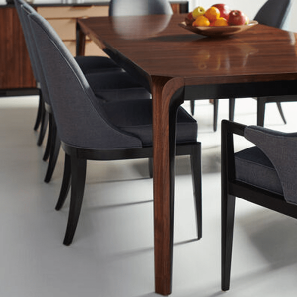 Room For More dining table shown from a corner with chairs too by Caracole.