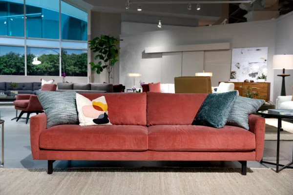 peach two seat sofa with blue pillows