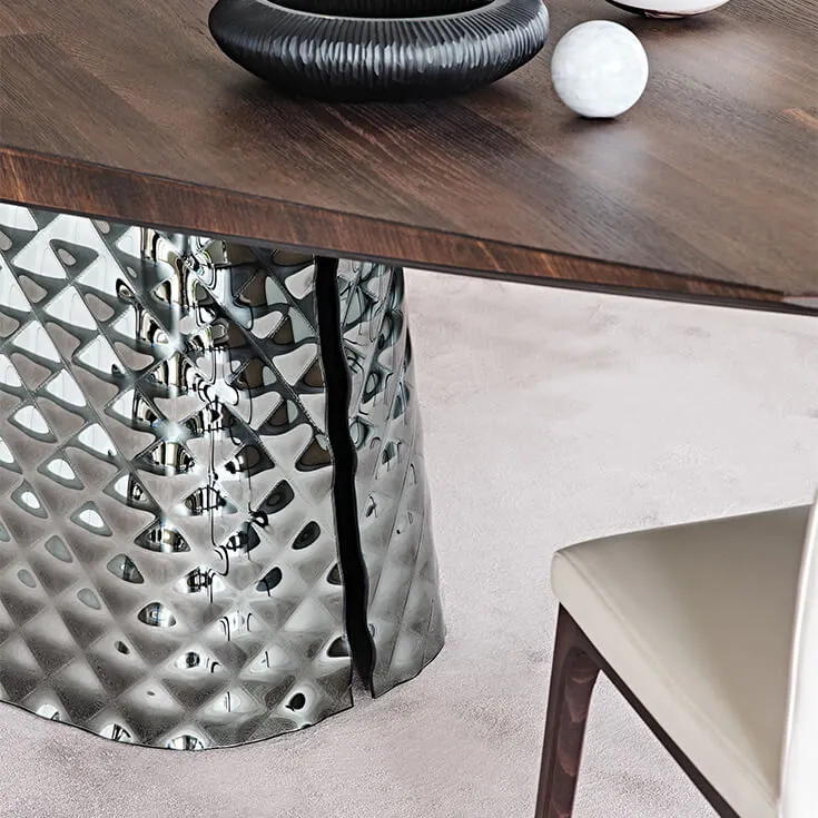 Cattelan Italia's Atrium Masterwood dining table burned oak wooden carved top and metal quilted base closeup detail shot at base slit.